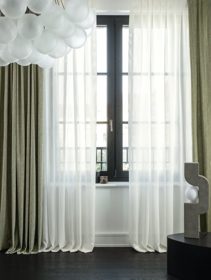 Bela in zelena prosojna zavesa po meri na velikem oknu v elegantni dnevni sobi